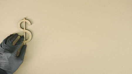 Putting dollar symbol made of recycled cardboard on the table. Sustainable economy or forex conceptsの写真素材