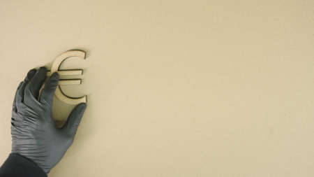 Putting euro symbol made of recycled cardboard on the table. Sustainable economy or forex conceptsの写真素材