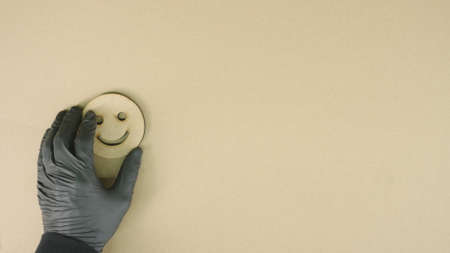Putting happy smiley icon made of recycled cardboard on the tableの写真素材