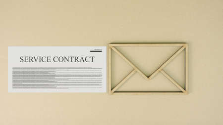 Service contract and the envelope icon on cardboard backgroundの写真素材