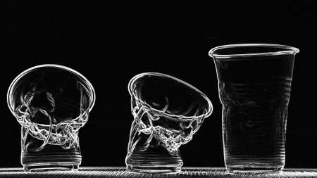 Crumpling plastic cups on black background, plastic pollution concept