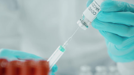 Doctor picks up coronavirus vaccine with a syringe, macro shot