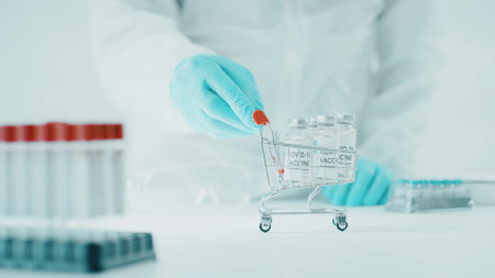 Scientist pushes a small shopping cart with new COVID-19 coronavirus vaccine vials. Research and delivery conceptsの写真素材