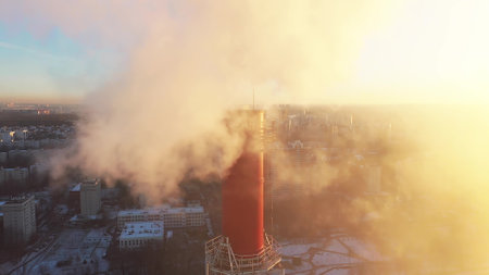 Aerial view of a red smoke stack in the city surroundingの写真素材