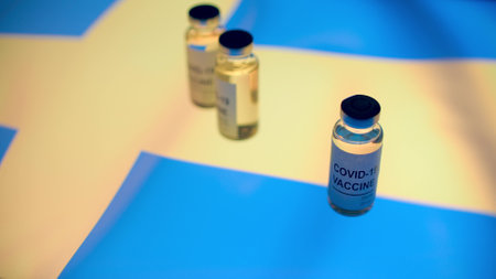 Medical bottles with COVID-19 vaccine and flag of Swedenの写真素材