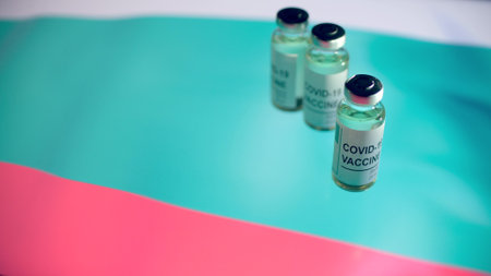 Bottles with COVID-19 vaccine and flag of Bulgaria