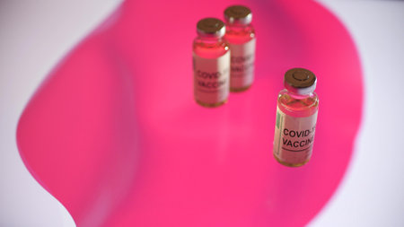 Glass vials with COVID-19 vaccine and flag of Japan