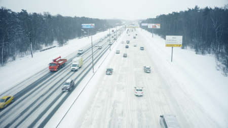 MOSCOW, RUSSIA - FEBRUARY 14, 2021. Low altitude aerial view of cars moving along the snow covered Moscow Ring Road in heavy snowfallのeditorial素材