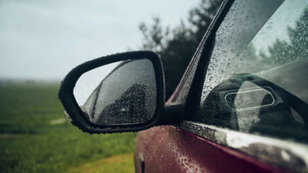 Rain drops on the rearview mirror of a car on a rainy dayの写真素材