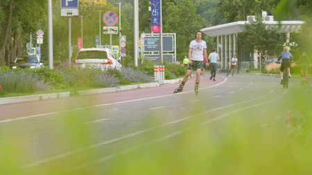 MOSCOW, RUSSIA - JULY 5, 2021. Slow motion shot of people skating and running in Luzhniki park area