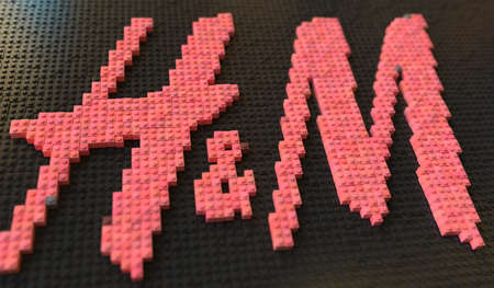 Logo of H and M made with plastic toy blocks, editorial conceptual 3d rendering