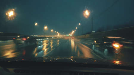POV car drivers shot. Driving along the highway in wet snow at night