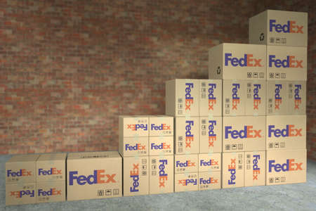 FEDEX logo on cartons with goods composing a rising bar chart. Editorial business growth concept, 3D...