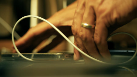 Man plugs out a phone charger from a modern smartphone, close-up shotの写真素材