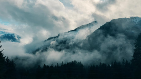 Fog and clouds curl on the fores covered slopes of the Swiss Alps near Lucerne. Switzerlandの写真素材
