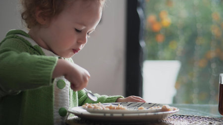 Little girl having oatmeal or porridge for breakfast at home. Healthy eatingの写真素材