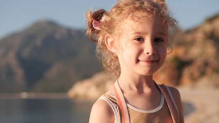 Smiling little girl on the beach close-upの写真素材