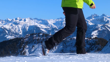Unknown hiker walking against beautiful snowy Swiss Alps backgroundの写真素材