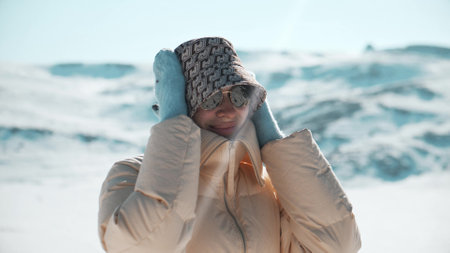 Portrait of a beautiful smiling woman wearing warm clothes in mountains in winterの写真素材