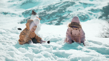 Little girls play in snow in winterの写真素材