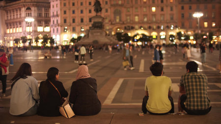Unknown tourists on crowded famous Piazza del Duomo or Cathedral Square in the centre of Milan in the evening, Italyの写真素材