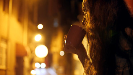 Beautiful woman relaxes on old town terrace in the eveningの写真素材
