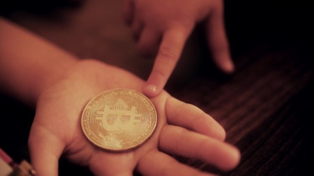Baby holds a bitcoin token or coinの写真素材
