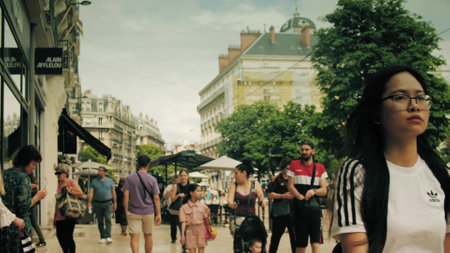 GRENOBLE, FRANCE - JUNE 6, 2023. People walk along the sidewalk in city centreのeditorial素材