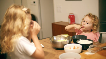 Two little girls cook together at homeの写真素材