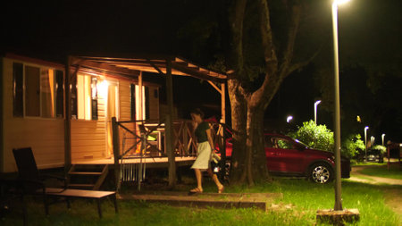 Beautiful woman walk to mobile camping home in the evening. Summer vacation house rentalの写真素材