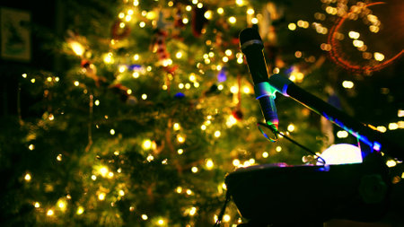 Microphone at decorated lit Christmas or New Year tree in the eveningの写真素材