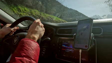 HUEZ, FRANCE - FEBRUARY 29, 2024. Driving a Renault Arkana along the scenic road in the French Alps