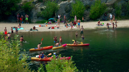 VERS-PONT-DU-GARD, FRANCE - AUGUST 2, 2023. People rowing kayaks along the River Gardon beach. Family vacation time in Franceのeditorial素材