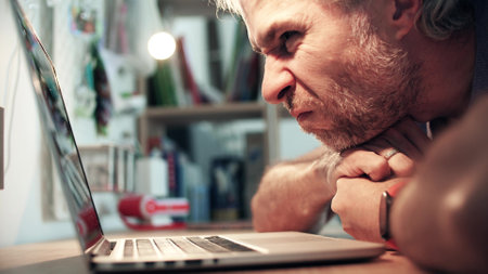 A skeptical unhappy man uses his laptop. Bad offer or poor user experience concepts