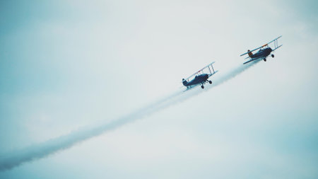 Two retro planes fly high in the sky togther. Teamwork or double effort conceptの写真素材