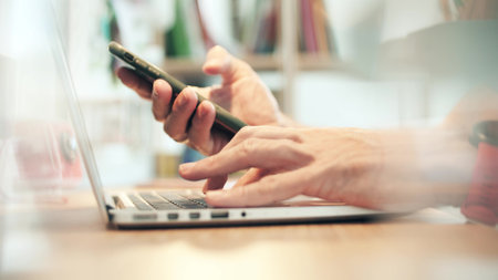 Hands on the keyboard and smartphone. Modern online work from home office concept