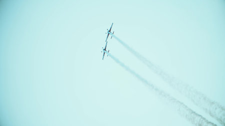Telephoto lens shot of two propeller planes performing aerobatics maneuvers during the airshow. Teamwork or double effort conceptの写真素材
