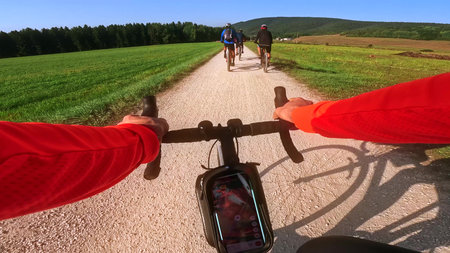 POV road cycling in Vercors overtaking mountain bikers on gravel path, Franceの写真素材
