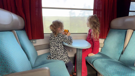 Two girls looking through train window during travel in Franceの写真素材