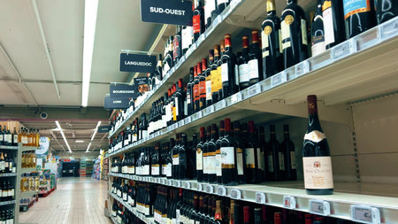 GRENOBLE, FRANCE - MARCH 1, 2026. French wine bottles on supermarket shelves in retail aisle