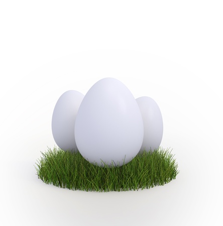 Three white  easter eggs in a small patch of grassの写真素材