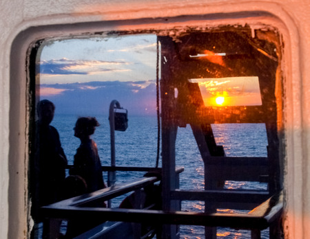 Corse - Corsica, France - September 12, 2014: Sunset reflected from the Window on ferryのeditorial素材