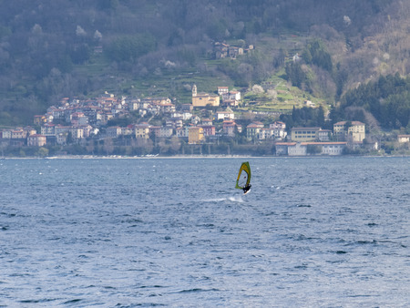 Pianello del Lario, Como - Italy - April 05, 2015: Windsurfer in a fun day of the Breva thermal wind typical of Lake Como during the spring / summer. The water temperature is slightly above the 10 degrees Celsius. The wind of around 16/18 knots.のeditorial素材