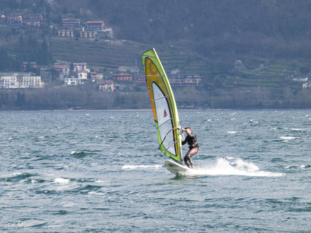 Pianello del Lario, Como - Italy - April 05, 2015: Windsurfer fun in a day of Breva the thermal wind typical of Lake Como during the spring / summer. The water temperature is slightly above the 10 degrees Celsius. The wind of around 16/18 knots.のeditorial素材