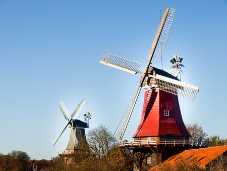 Greetsiel, Germany - November 4, 2011: Traditional Dutch windmills working and still used to grind. The green, western mill dates from 1856, the red, eastern mill was built in 1706.のeditorial素材