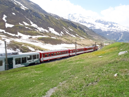 Andermatt, Switzerland - June 4, 2015: Matterhorn Gotthard train through the valley that leads up to the Oberalp pass.のeditorial素材