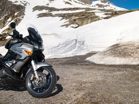 Gotthardpass, Switzerland - May 14, 2015: Vehicles in transit between the walls of snow The pass is still a lot of snow in the winterのeditorial素材