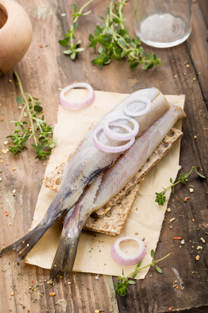fresh matjes on wooden background with onionsの写真素材