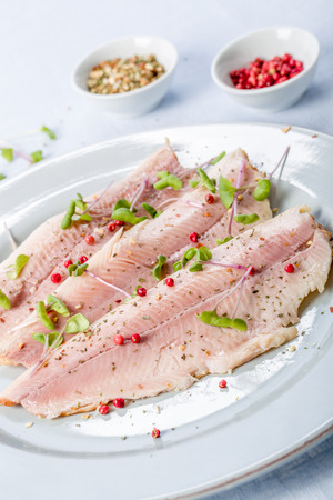 smoked trout fillet with pink pepper and fresh cressの写真素材