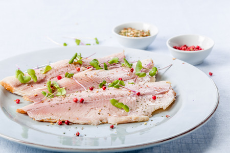 smoked trout fillet with pink pepper and fresh cressの写真素材